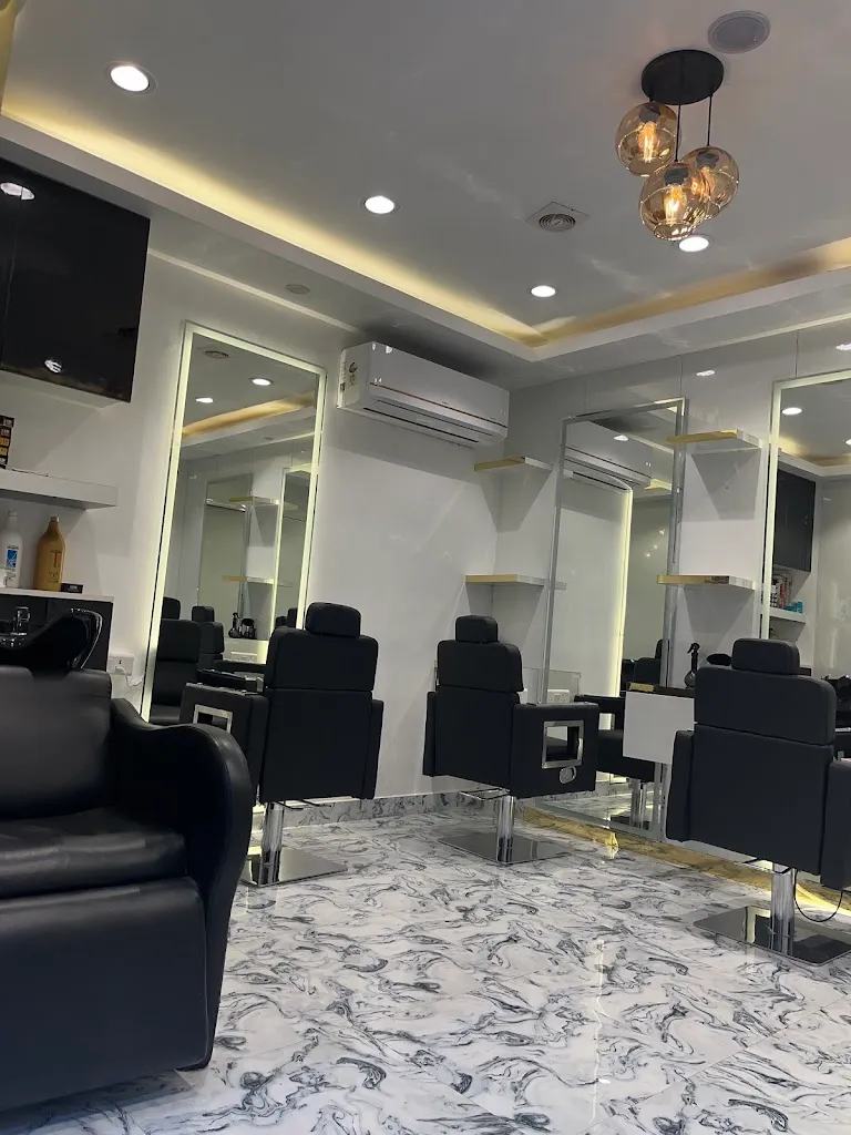 The styling floor at Wanna Cut Unisex Salon: chairs, arched mirrors and marble flooring